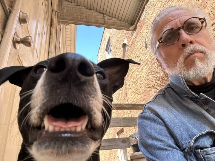 Kent Maynard sitting outdoors with a black-and-white dog